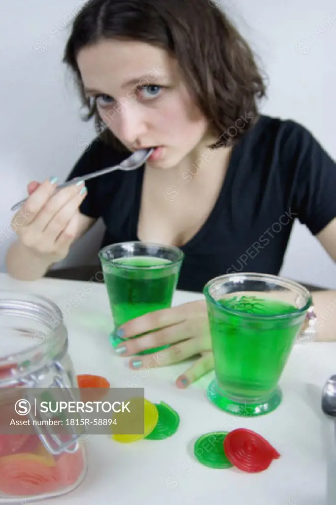 Young woman eating green jelly