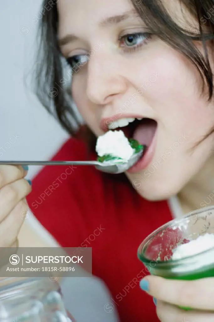 Young woman eating green jelly