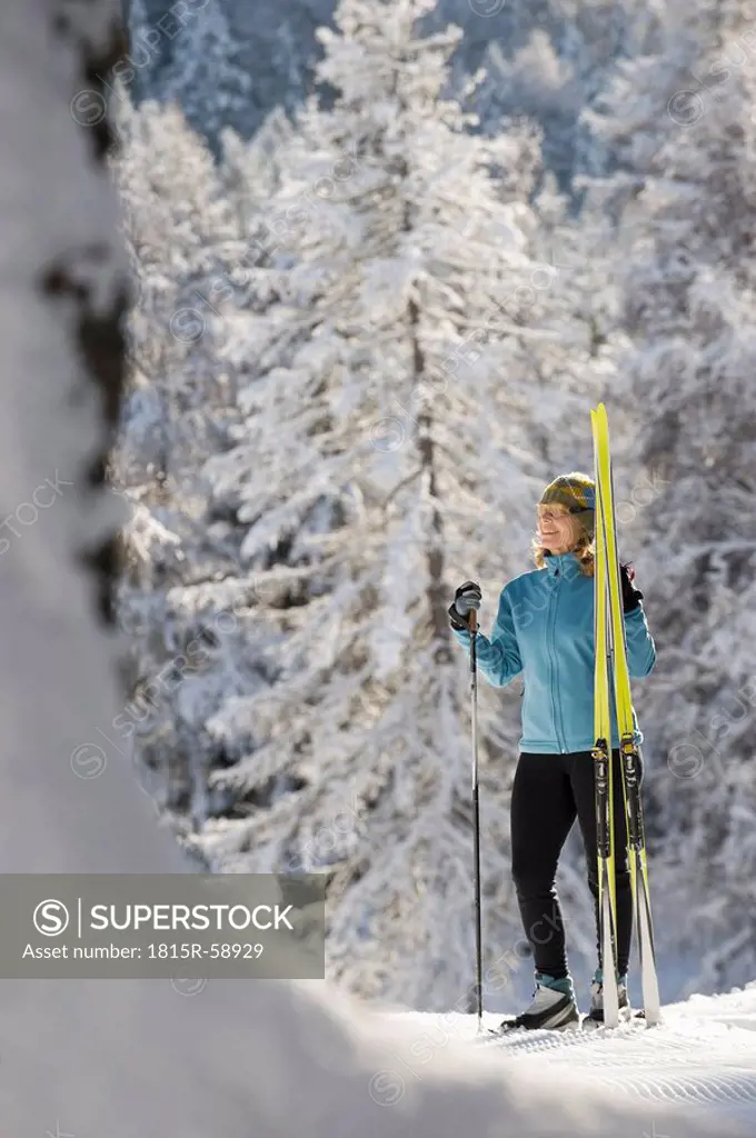 Austria,Tyrol, Seefeld, Wildmoosalm, Woman holding cross_country skis