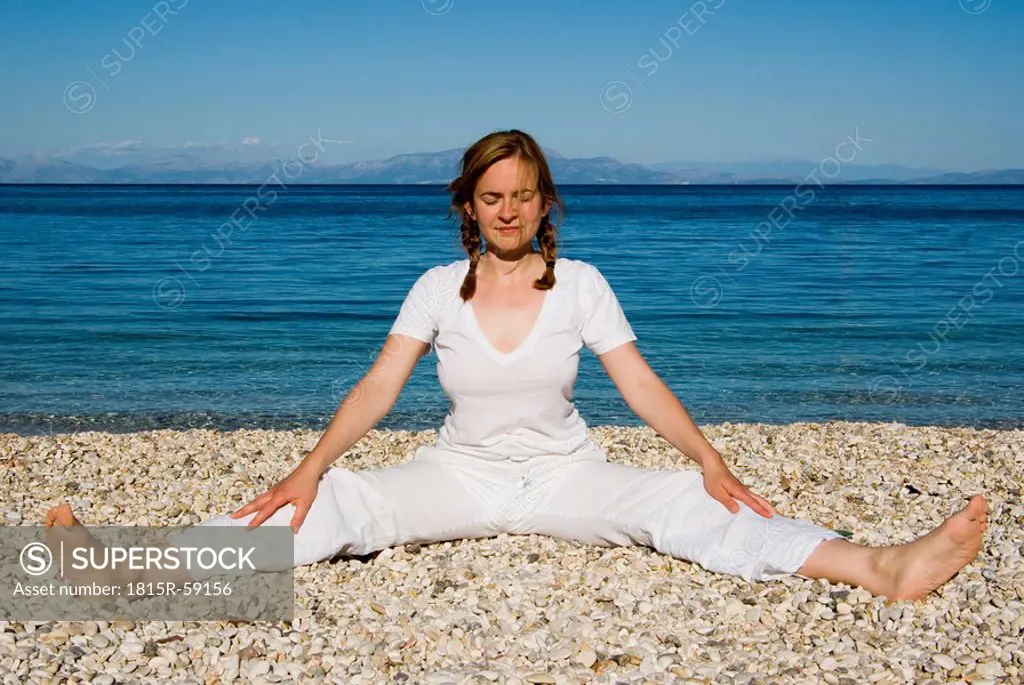 Greece, Ithaca, Woman exercising yoga on beach
