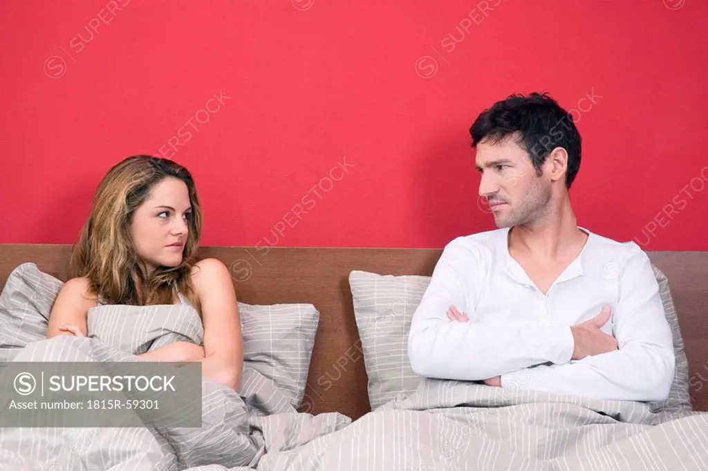 Frustrated couple in bed, portrait