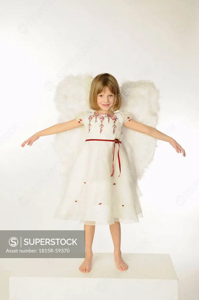 Little girl 6_7 wearing angel wings, arms out