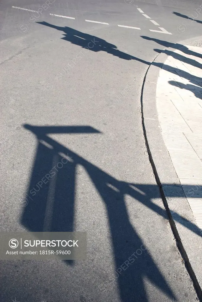 Silhouettes of street signs and people on sidewalk