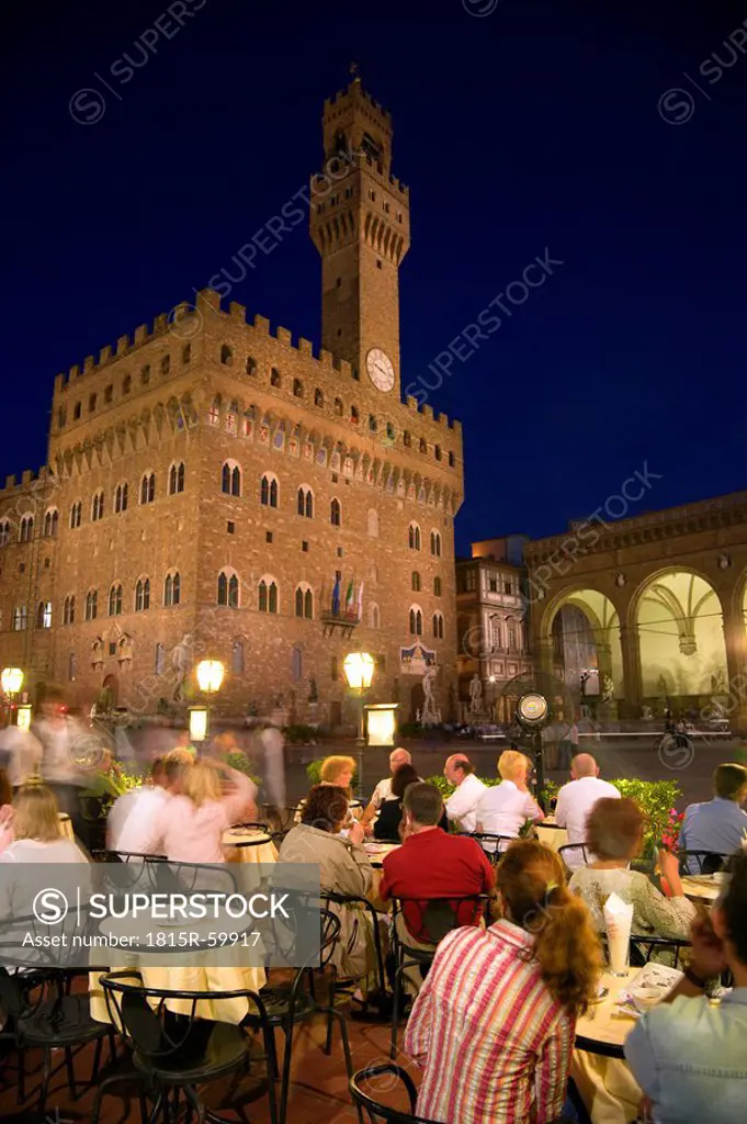Italy, Tuscany, Florence, Palazzo Vecchio at night, sidewalk cafe in foreground