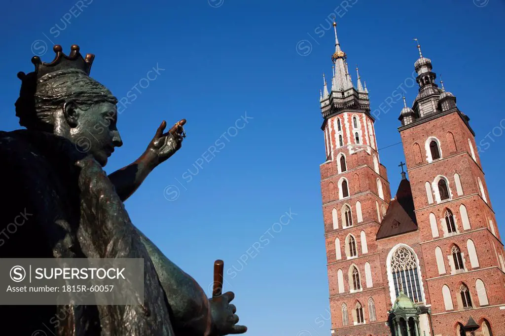 Poland, Cracow, St Marys church and sculpture in foreground