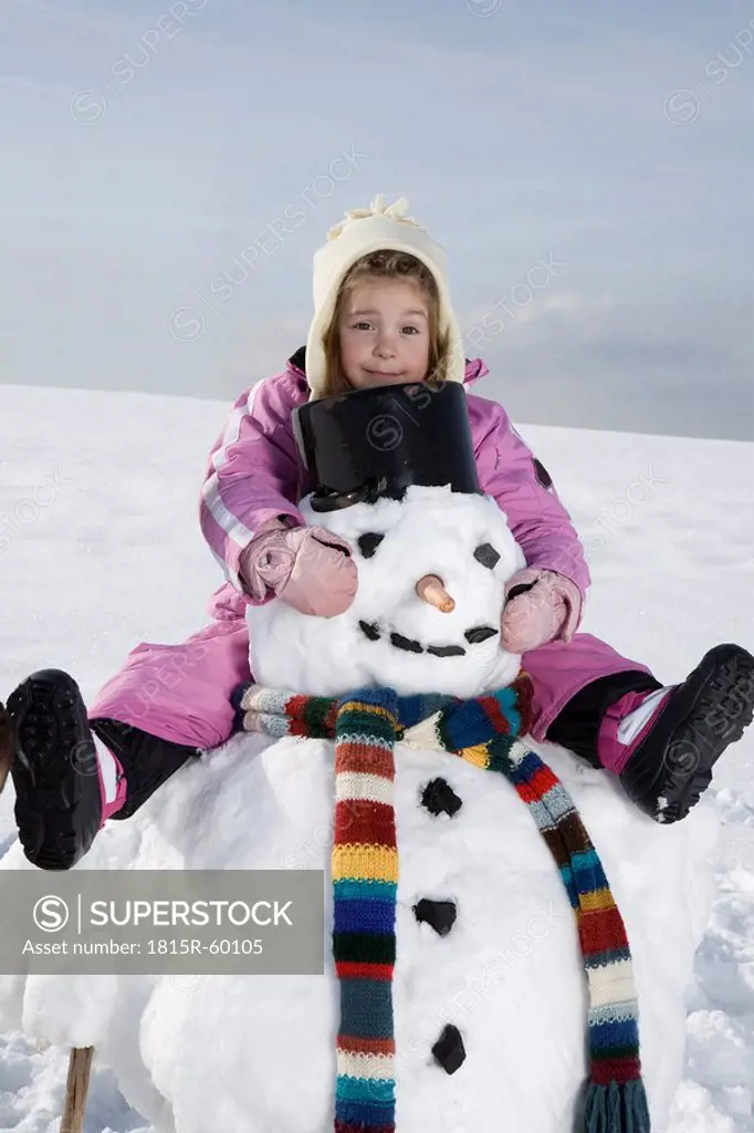 Germany, Bavaria, Munich, Girl 4_5 sitting on snowman, portrait