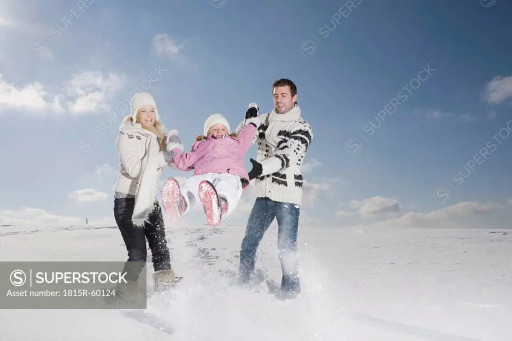 Germany, Bavaria, Munich, Family with daughter 6_7 in snowy landscape, having fun