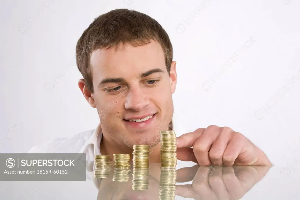 Young man counting Euro coins, portrait