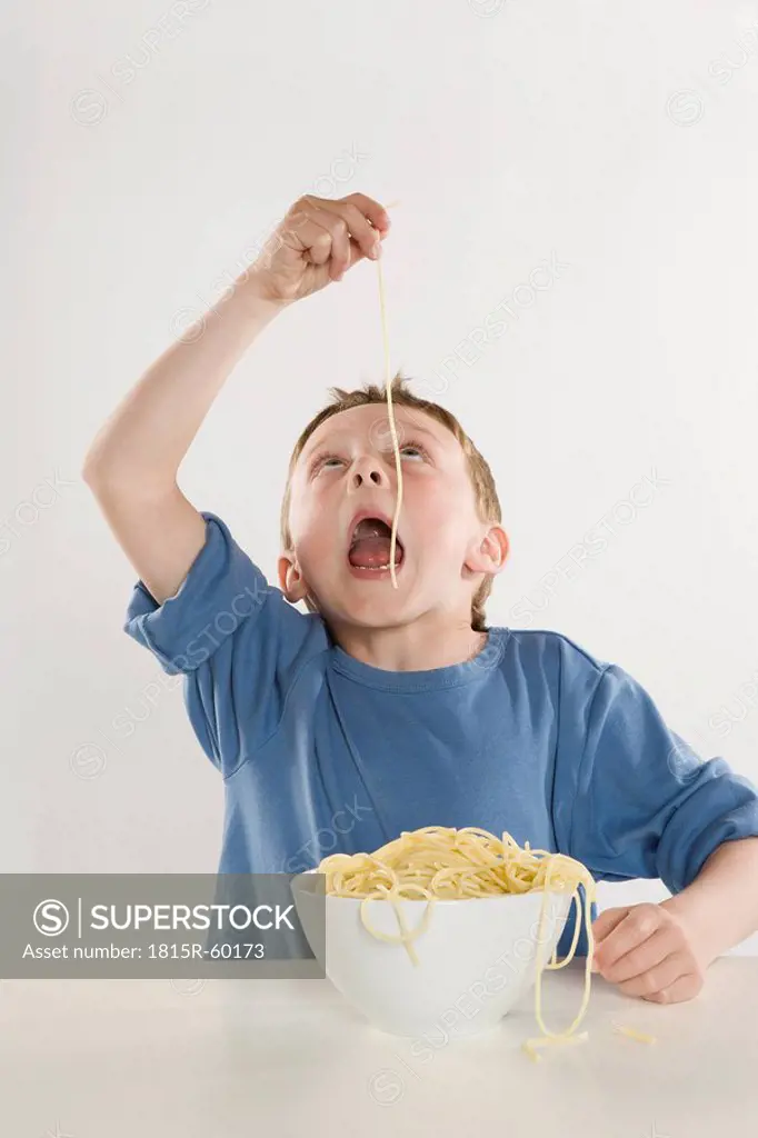 Boy 6_7 eating single spaghetti noodle