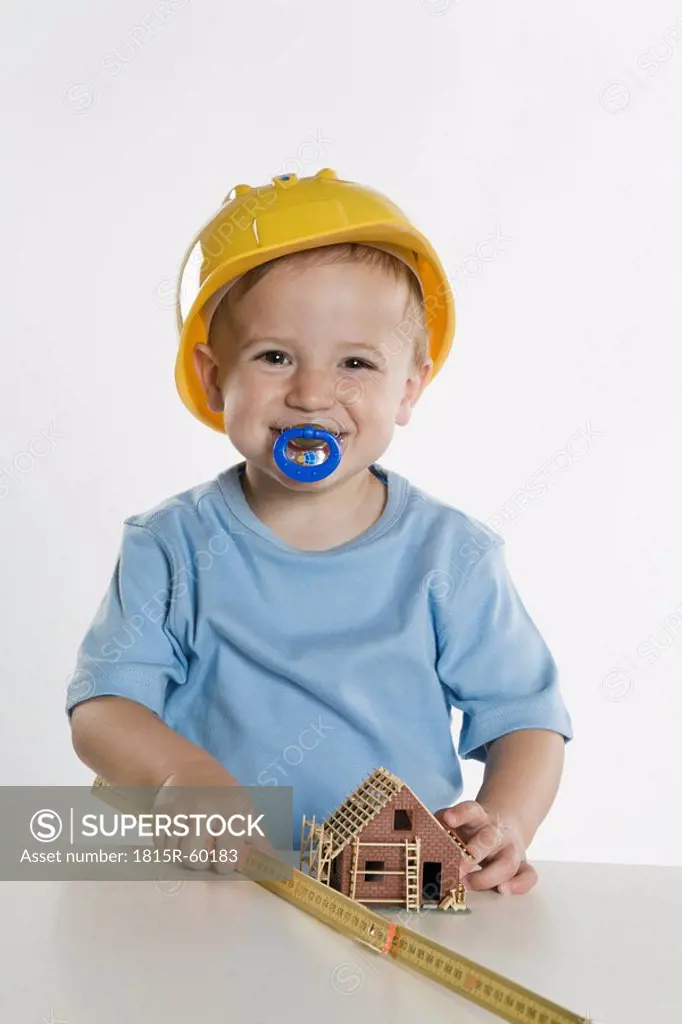 Boy 2_3 wearing hard hat, playing with folding rule