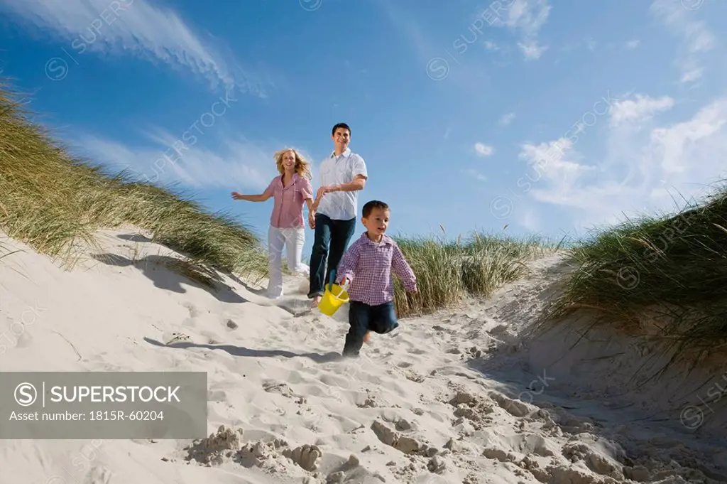 Germany, Schleswig Holstein, Amrum, Family running down beach dune