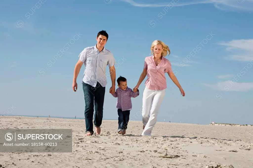 Germany, Schleswig Holstein, Amrum, Family taking a walk across beach