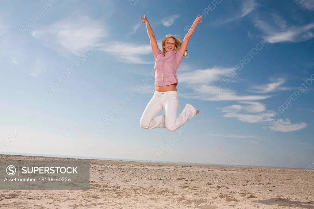 Germany, Schleswig Holstein, Amrum, Woman jumping on beach