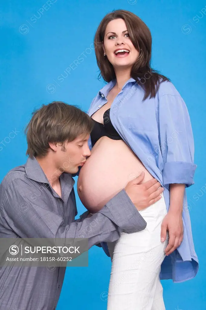 Man kissing his pregnant wife´s belly, portrait