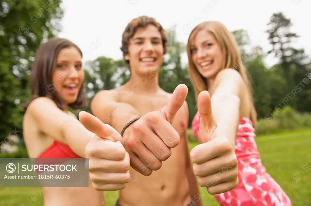 Germany, Bavaria, Starnberger See, Young people giving thumbs up, smiling, portrait, close_up