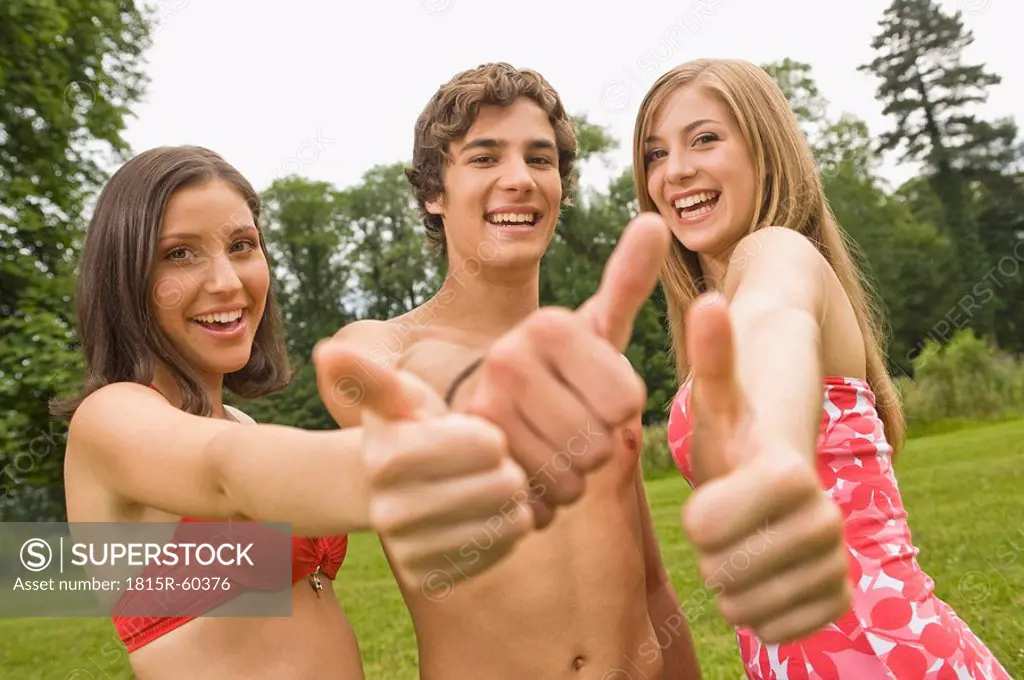 Germany, Bavaria, Starnberger See, Young persons giving thumbs up, smiling, portrait, close_up