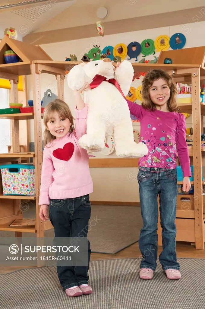 Germany,Two girls 4_5, 6_7 holding teddy, smiling, portrait