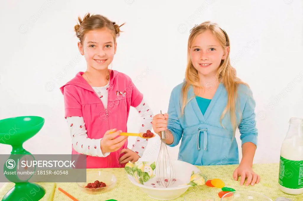 Two girls in the kitchen preparing meal, portrait