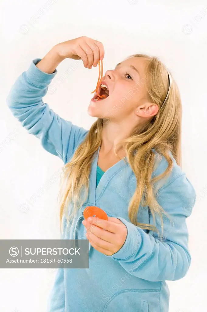 Girl 8_9 eating wine gum, smiling, portrait