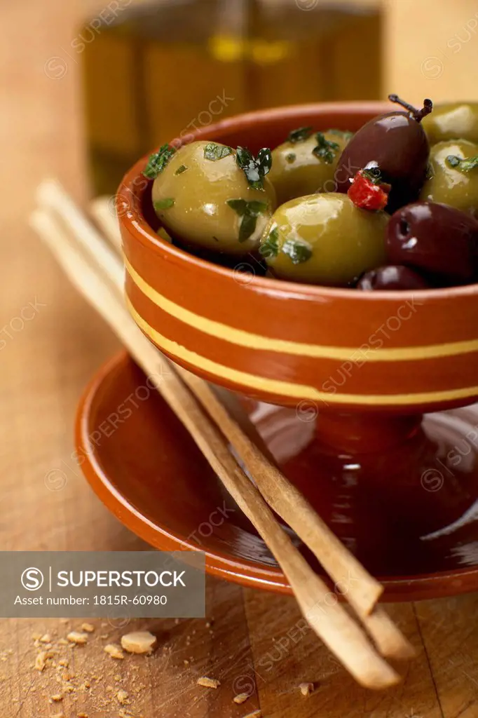 Olives with grissinis in bowl