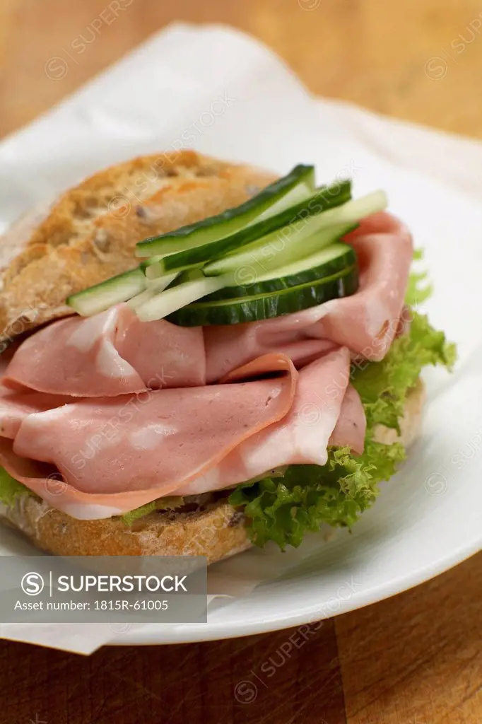 Sandwich with mortadella, salad and cucumber slices, close_up