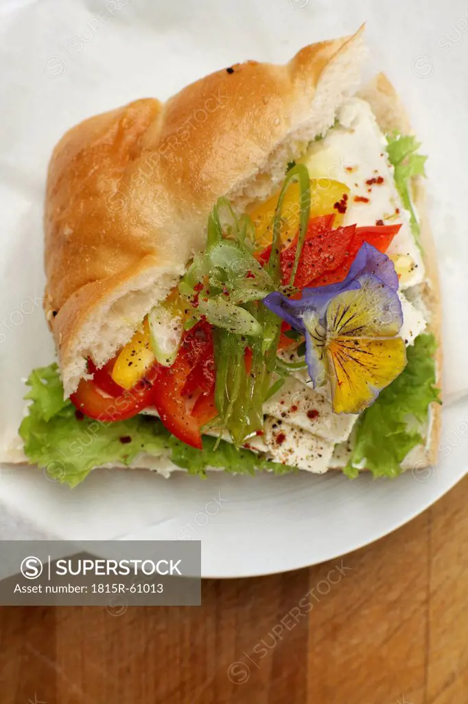 Pita sandwich with bell pepper and feta cheese on plate, elevated view