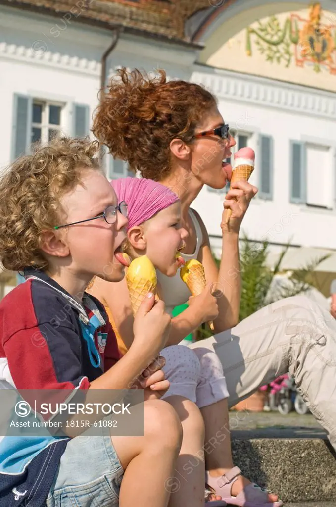 Germany, Baden_Württemberg, Lake Bodensee, Mother and two children 3_5 eating ice cream cones