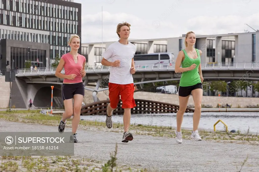 Germany, Berlin, Three friends jogging in the city