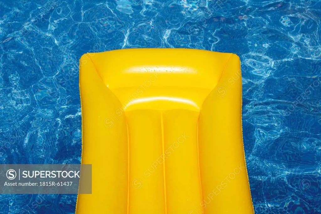 Yellow airbed floating in pool, elevated view