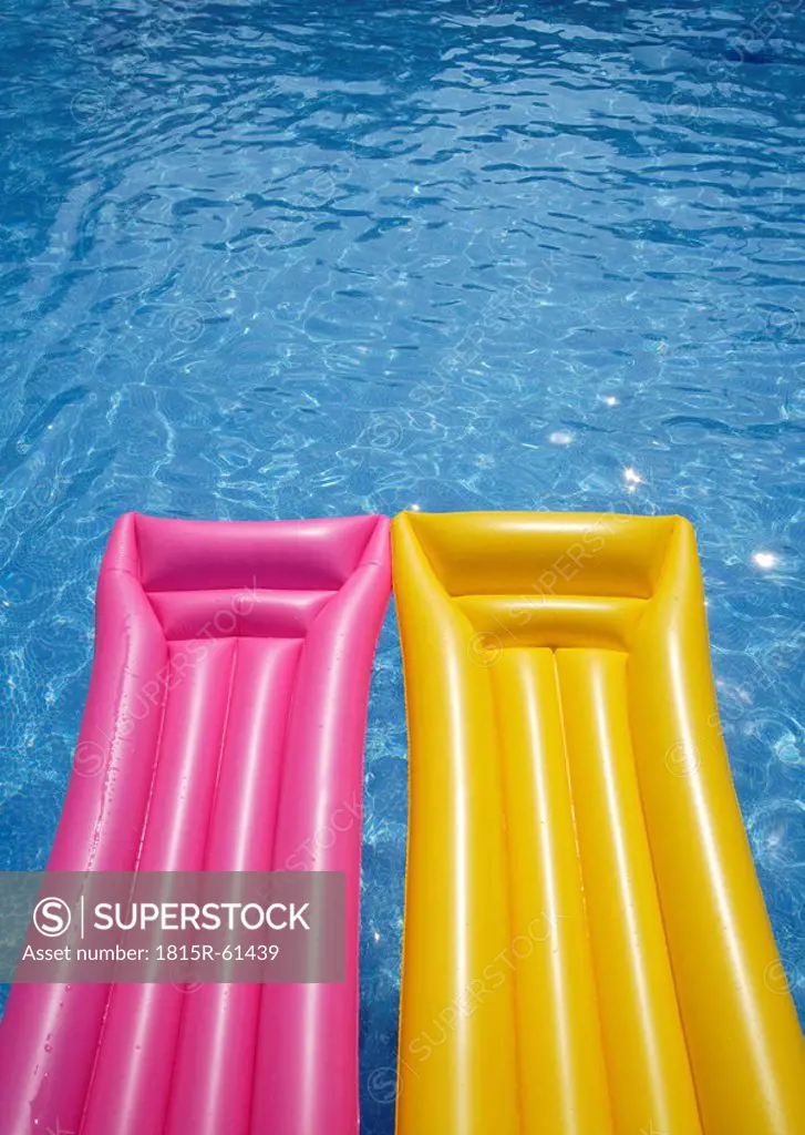 Two airbeds floating in pool, elevated view