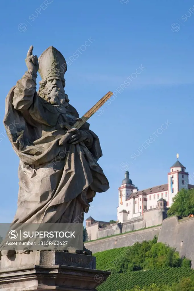 Germany, Bavaria, Franconia, Stone_Carved Statue of a Saint and the Marienberg Fortress