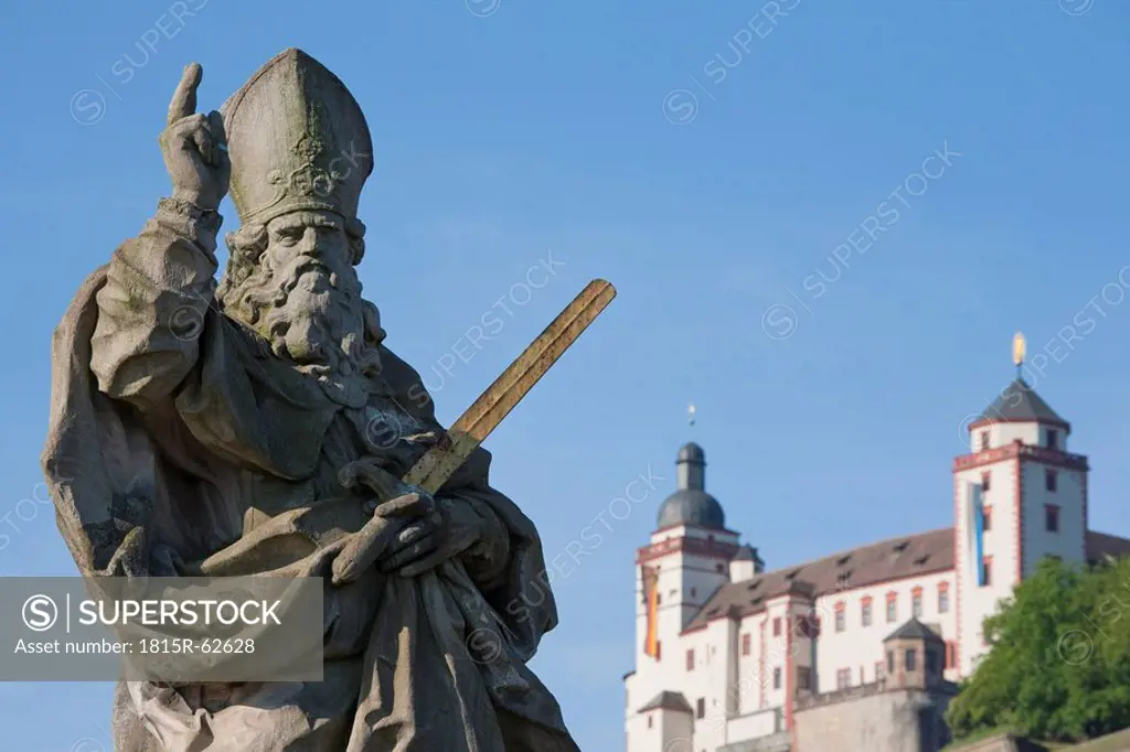 Germany, Bavaria, Franconia, Stone_Carved Statue of a Saint and the Marienberg Fortress