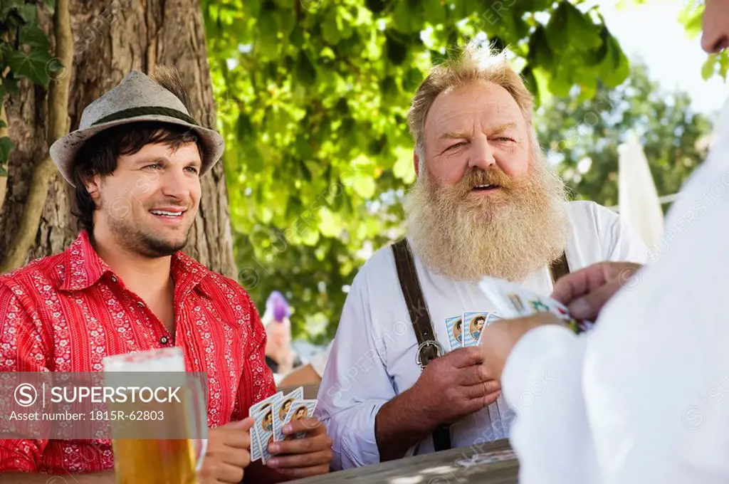 Germany, Bavaria, Upper Bavaria, Men playing cards in beer garden