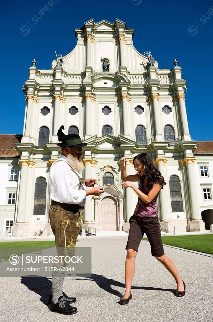 Germany, Bavaria, Upper Bavaria, Asian woman taking picture of Bavarian man with camera phone