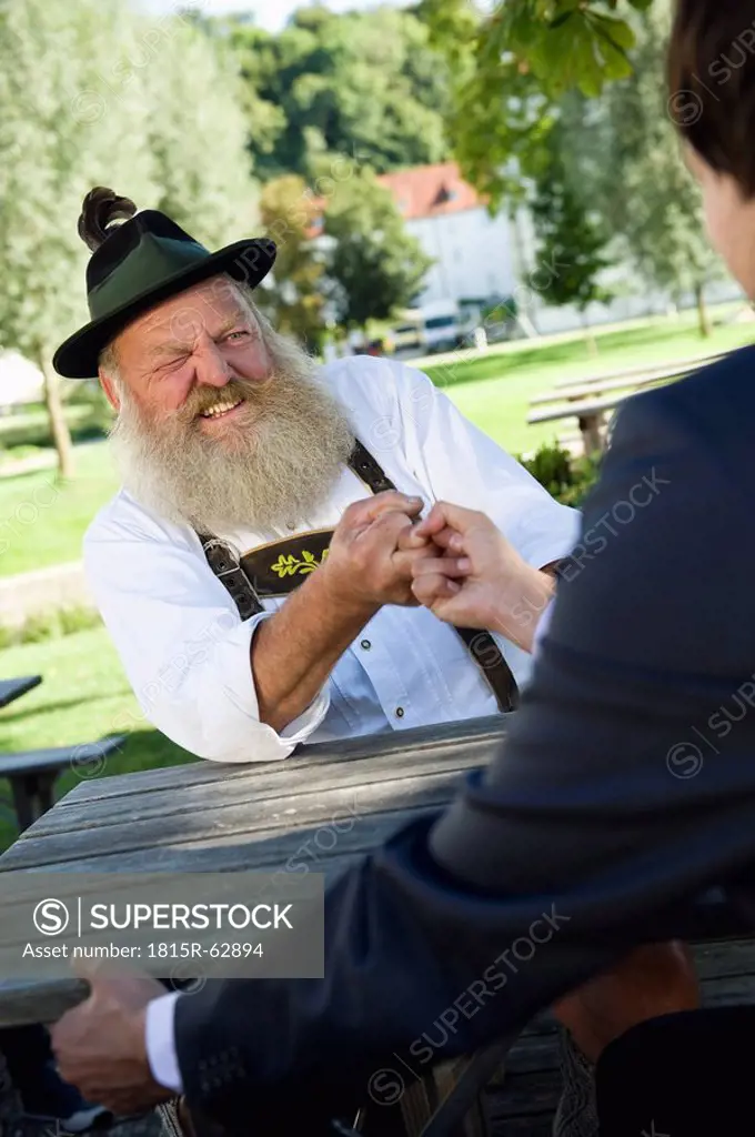 Germany, Bavaria, Upper Bavaria, Two men in beer garden finger wrestling