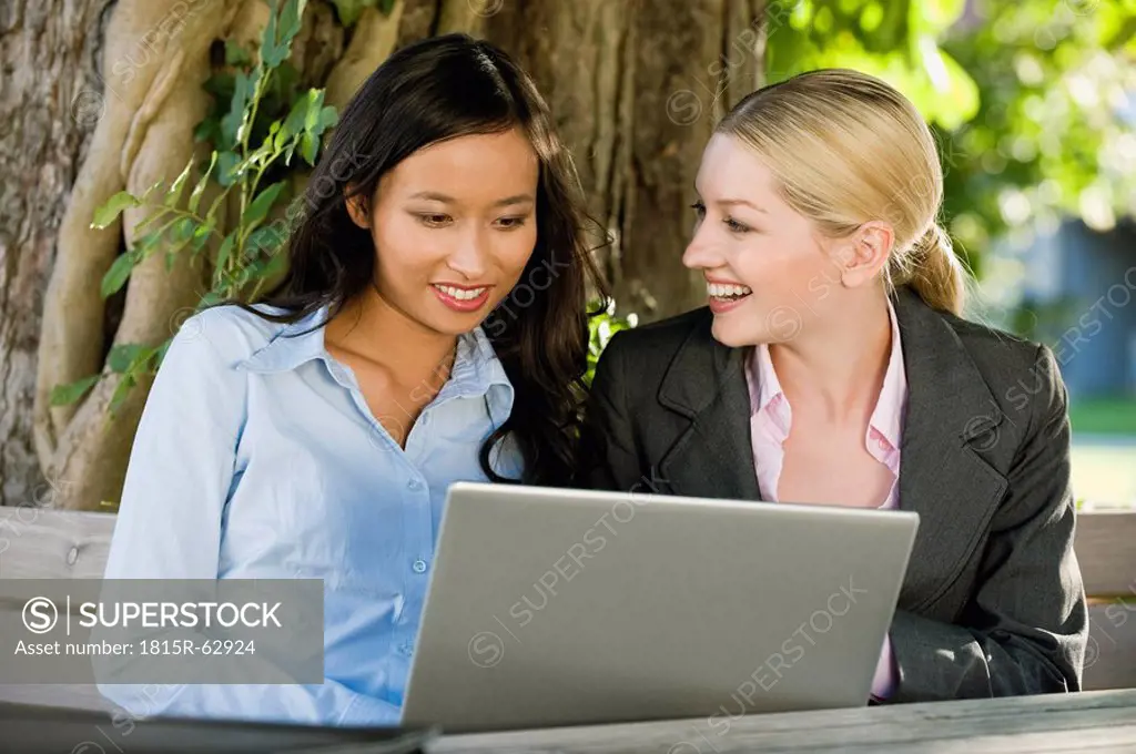 Germany, Bavaria, Upper Bavaria, Two Business women in beer garden using laptop