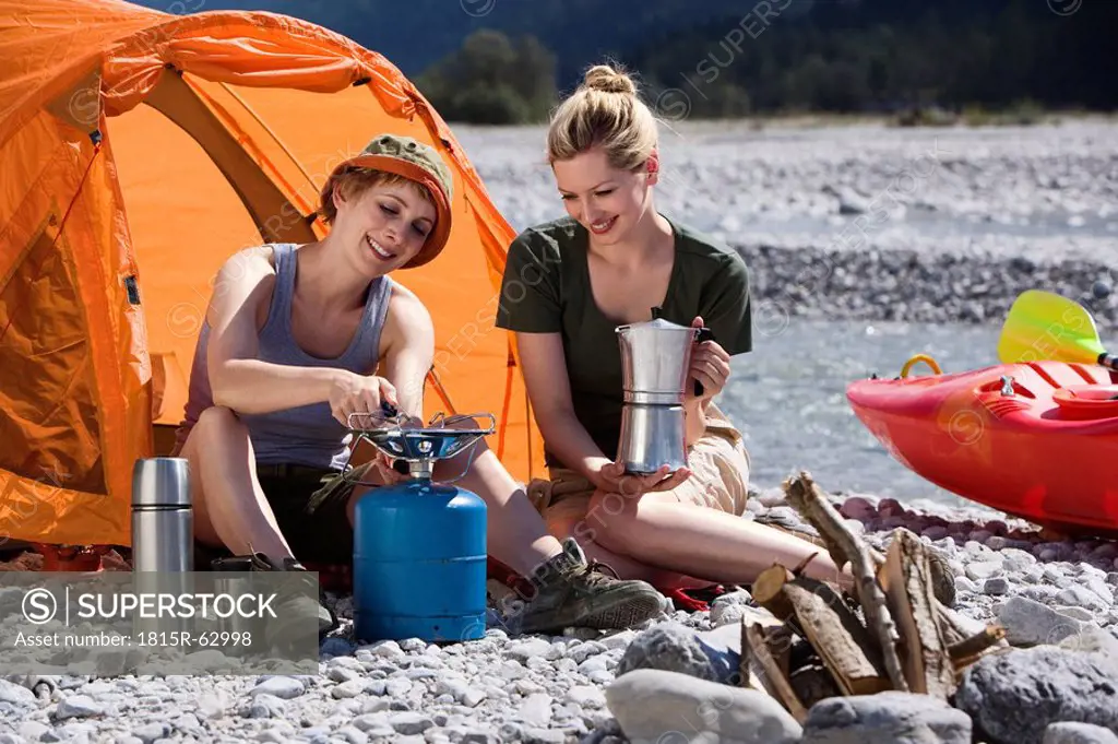 Germany, Bavaria, Tölzer Land, Young woman lighting camp stove