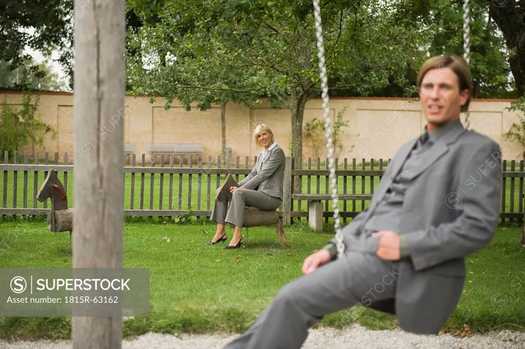 Germany, business people sitting in playground