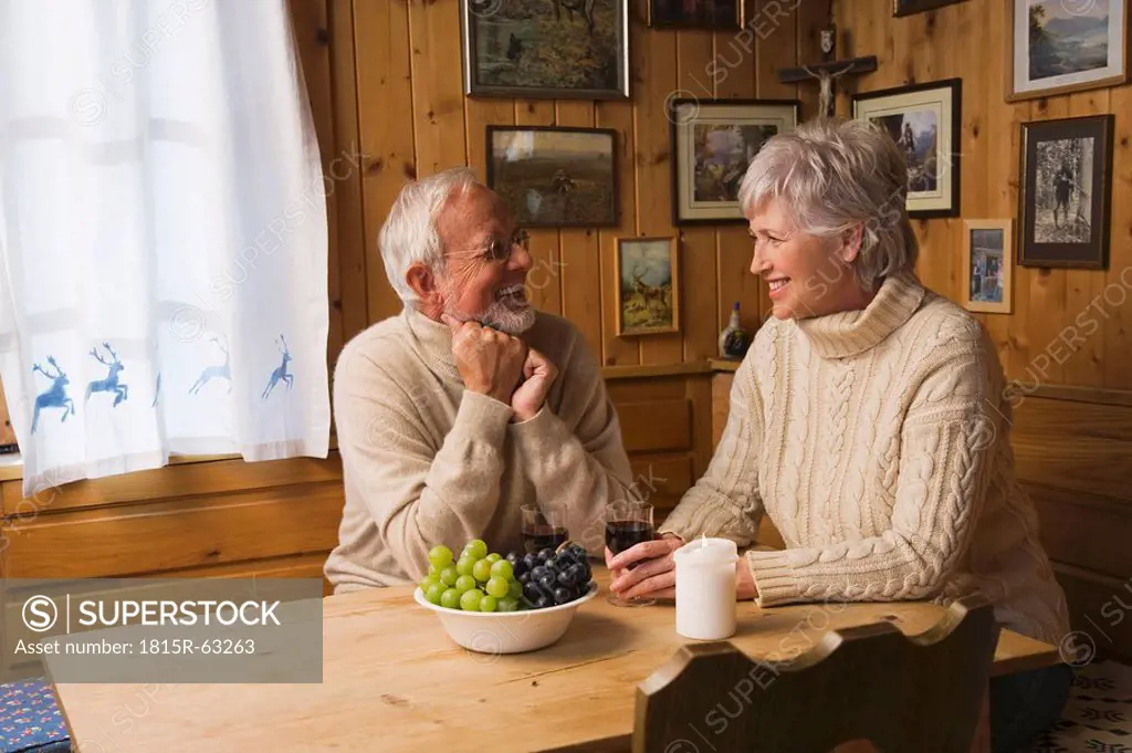 Senior couple sitting at table, smiling