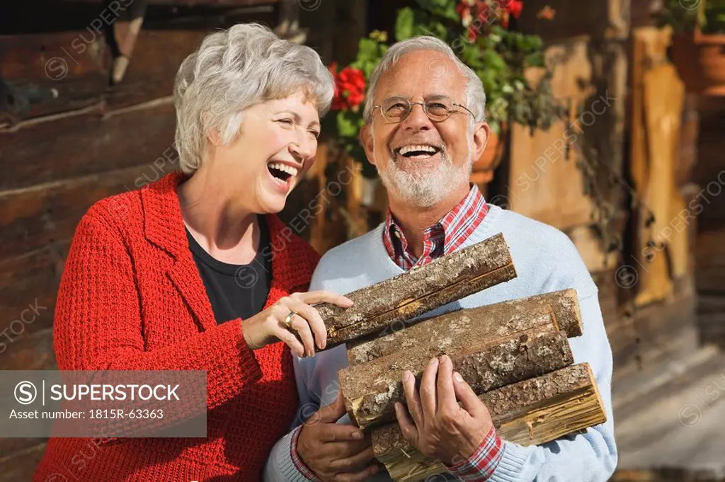 Austria, Karwendel, Senior couple carrying firewood, portrait