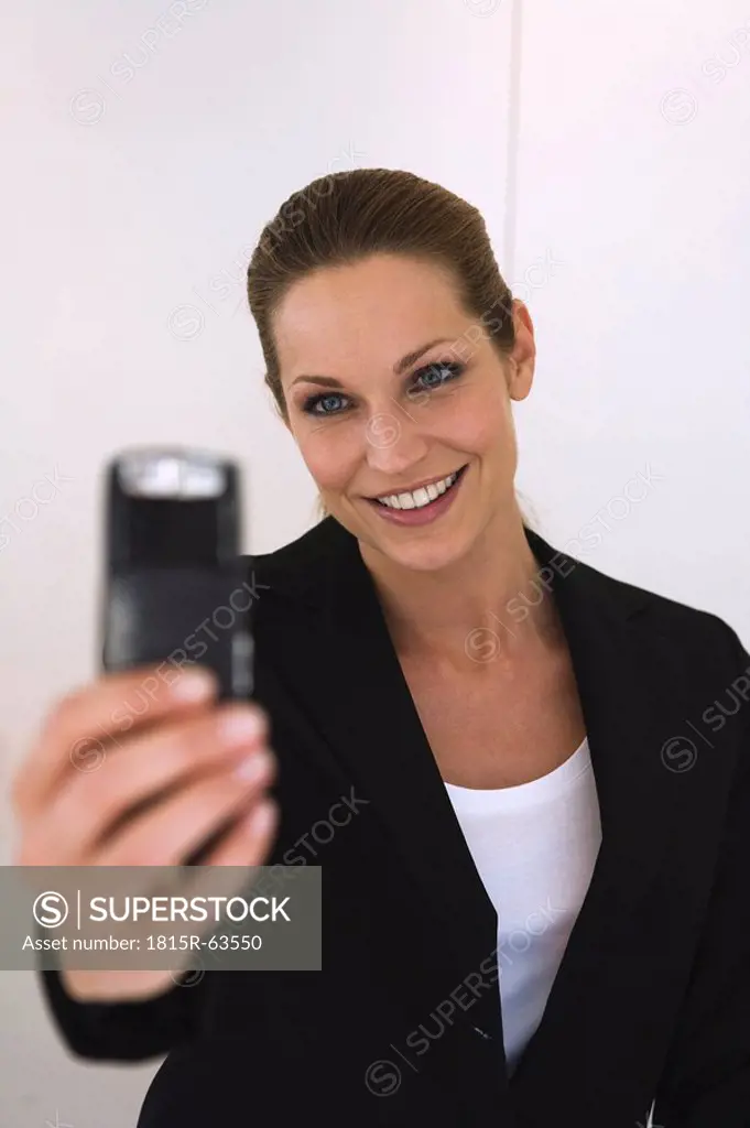 Business woman holding mobile phone, portrait