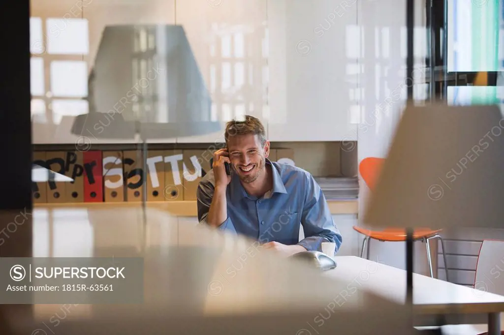 Young man in office using telephone