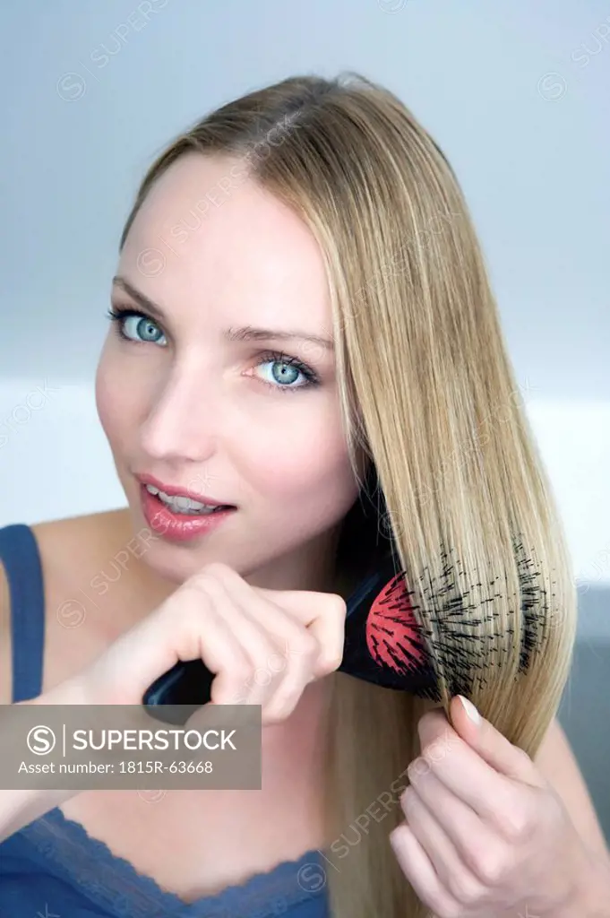 Young woman brushing her hair, portrait