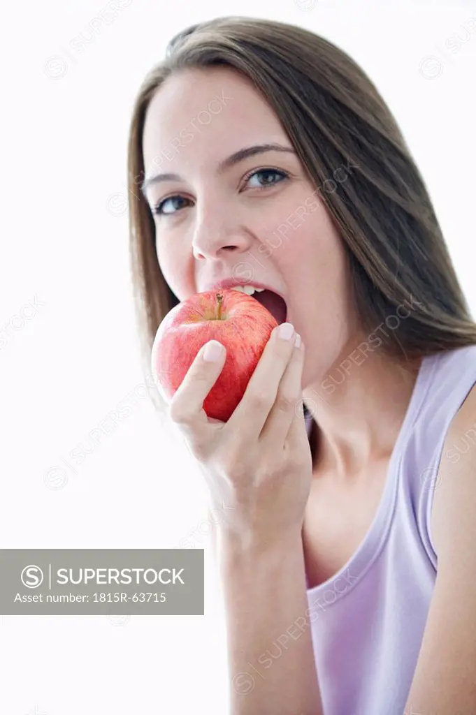 Young woman biting apple, portrait, close_up