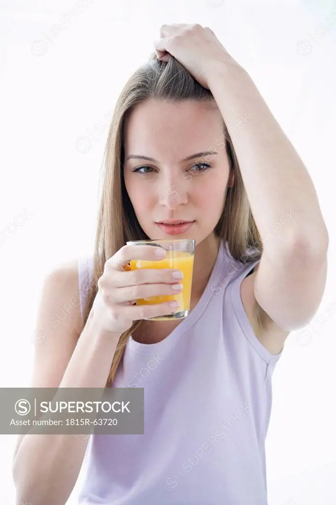 Young woman holding glass of juice, portrait