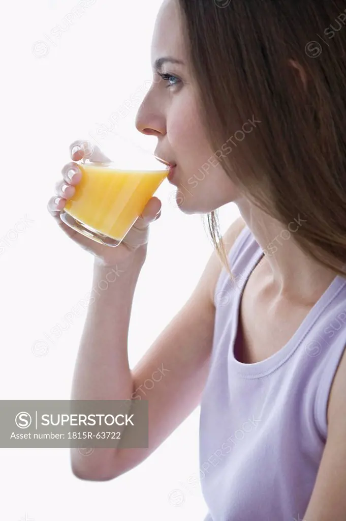 Young woman drinking orange juice, portrait, side view, close_up