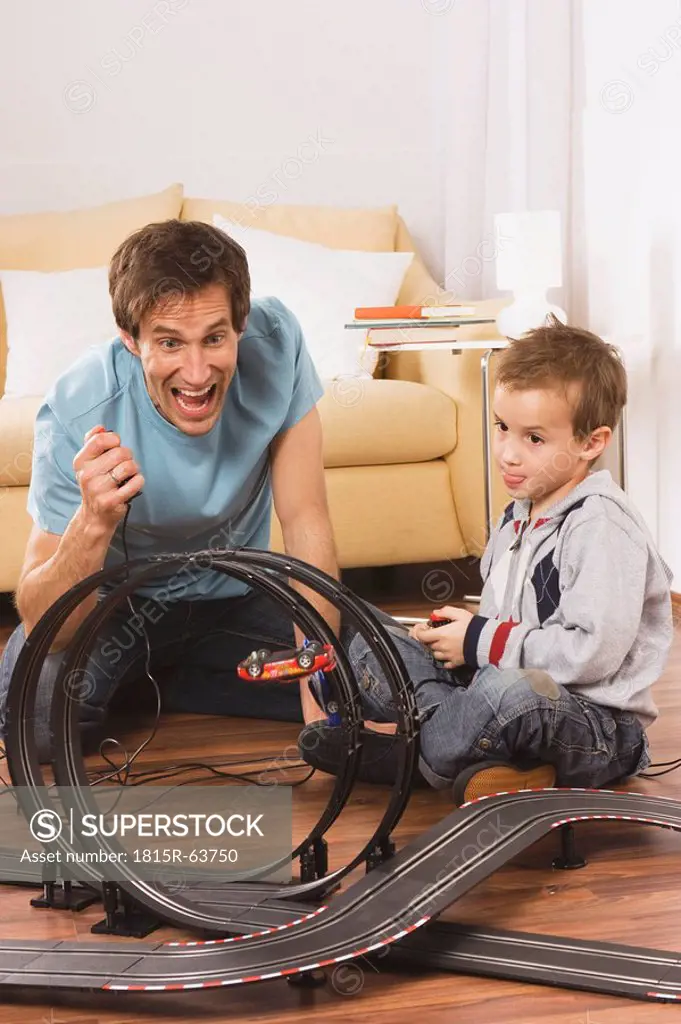 Father and son 4_5 playing with toy racetrack