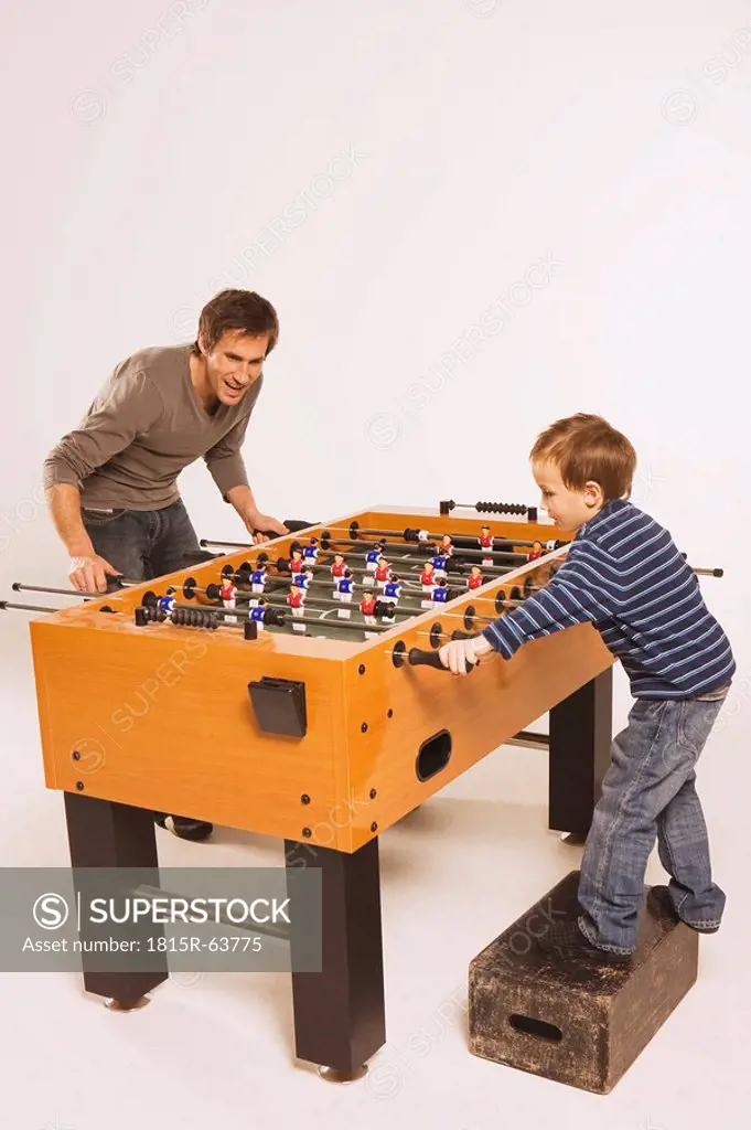 Father and son 4_5 playing tabletop soccer