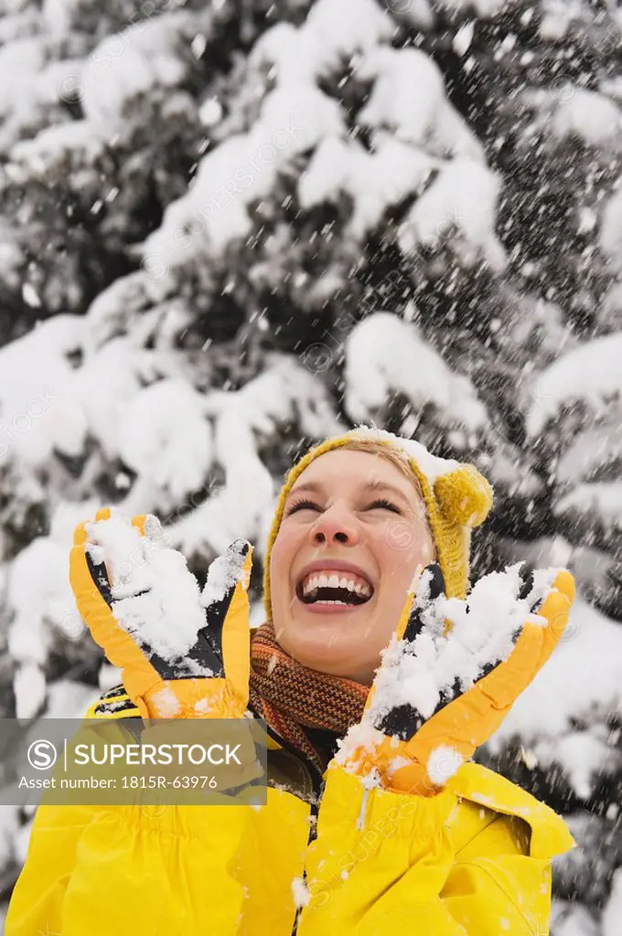 Italy, South Tyrol, Young woman fooling about with snow, portrait