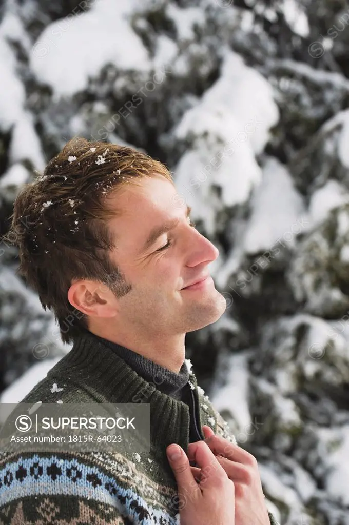 Italy, South Tyrol, Young man, eyes closed, smiling, portrait